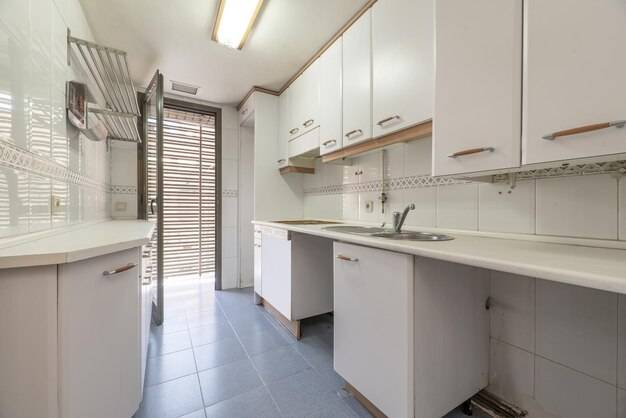 Простая кухня с белой мебелью и столешницей того же цвета с деталями цвета дерев