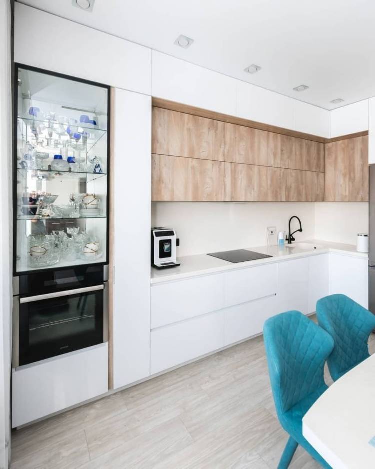 Белая угловая кухня со стеклянной витриной и бутылочницей