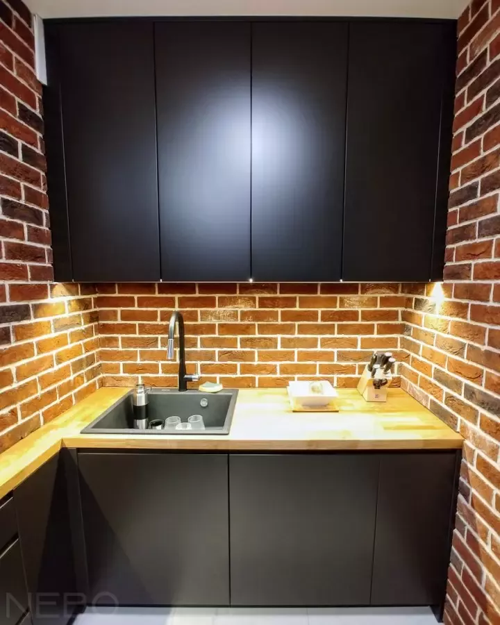 Черная кухня в стиле Лофт со столешницей из массива в интерьере со стенами из красного кирпич