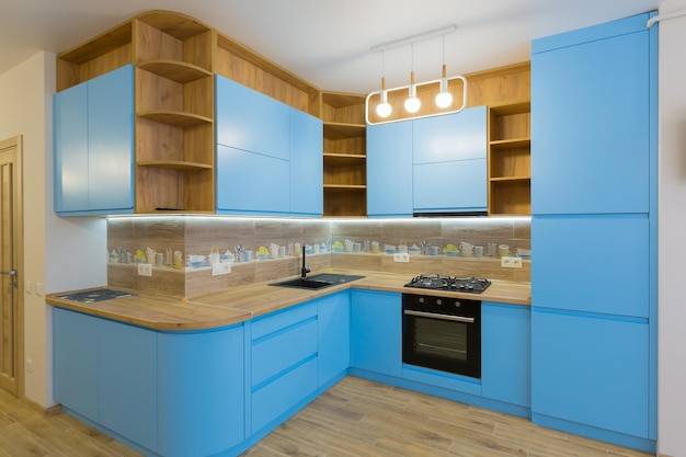 Интерьер большой голубой кухни с деревом в квартир