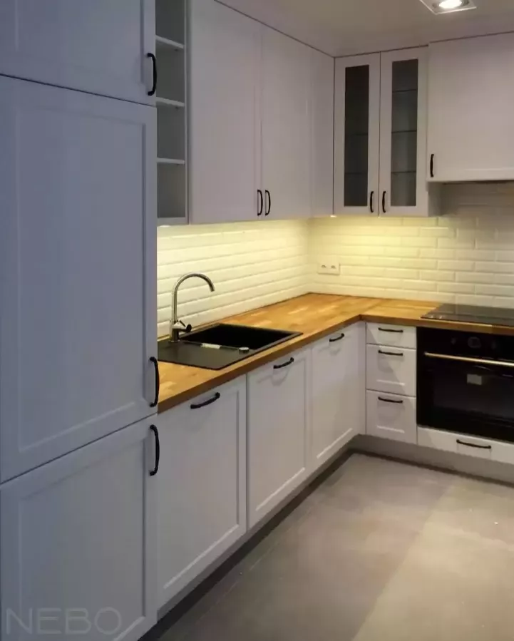 Классическая белая кухня с закрытыми фрезерованными фасадами из МДФ крашенного и витринами, с черными ручками