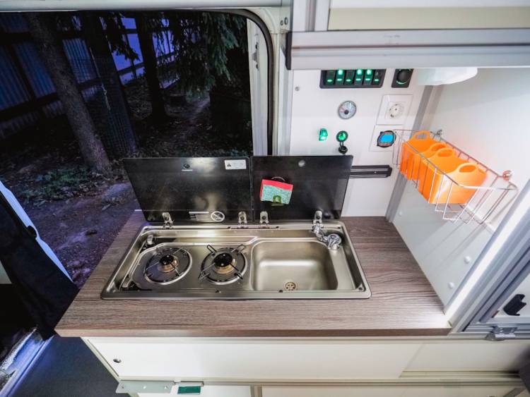 Душ, туалет, кухня и кровать в маленьком микроавтобус
