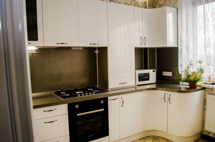 Белая угловая глянцевая кухня с радиусными фасадами в стиле модер