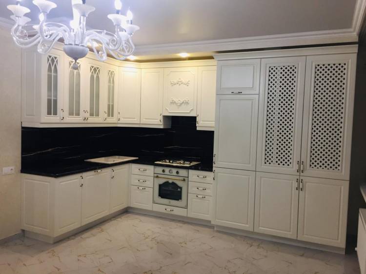 Белая угловая кухня с крашеными фасадами в классическом стиле с пластиковой столешницей