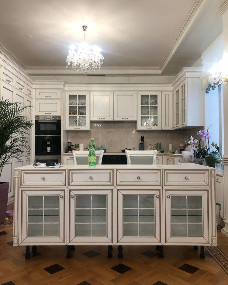 Белая угловая кухня из массива в классическом стиле с кварцевой столешницей