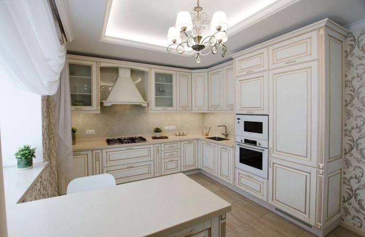 Светлая угловая кухня с крашеными фасадами в классическом стиле со столешницей из натурального камня