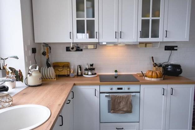 Белая уютная кухня в скандинавском стиле лофт домашний интерьер столовая дизайн духовка варочная панель стол кухонная мебель