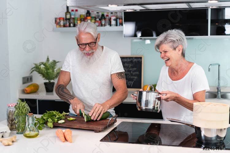 пожилая пара, готовая дома во время приготовления обед