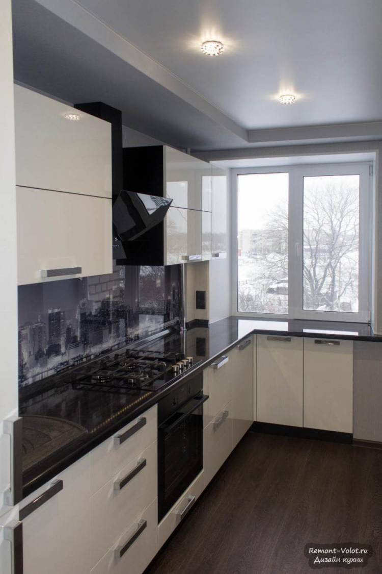Черно-белая кухня с глянцевыми фасадами и фартуком из стекл