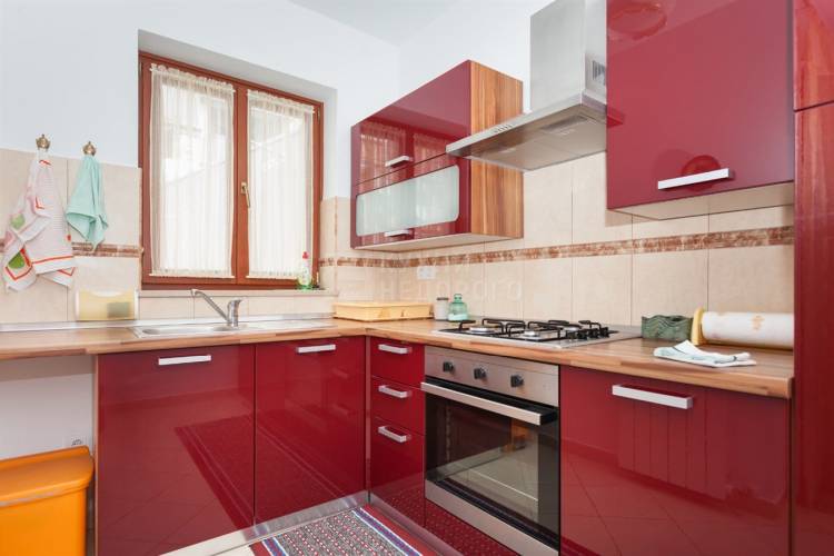 Красная кухня с деревянной столешницей