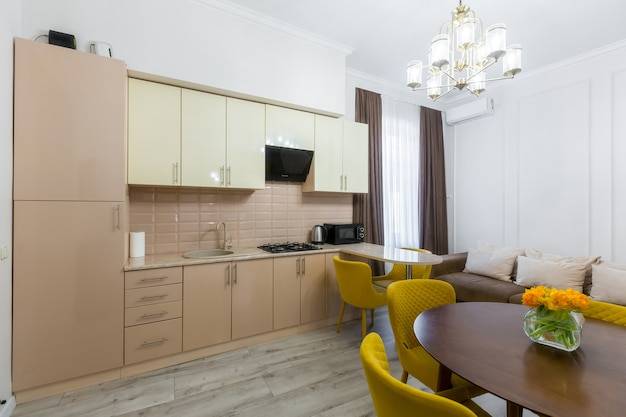 Интерьер современной стильной кухни в малогабаритной квартире, с мебелью, в пастельных тонах, желтый с бежевым