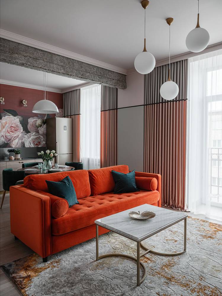 Оранжевый диван и цветы на стенах
