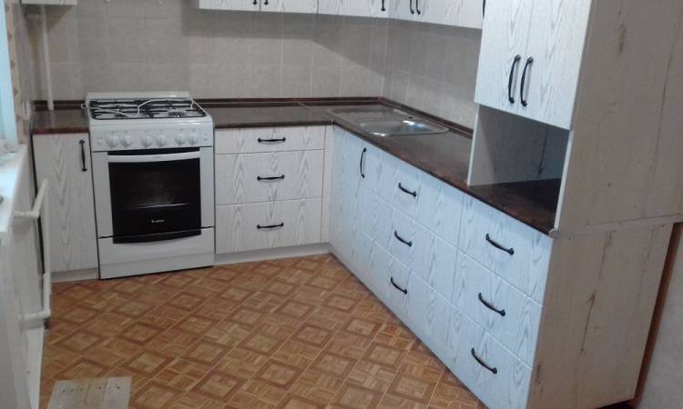 Белая угловая кухня в маленьком помещении с газовой плитой