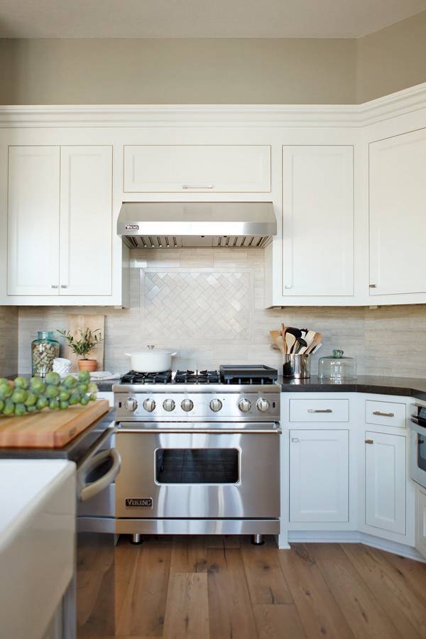 Светло-коричневый ламинат и окрашенный белой краской потолок современной кухни