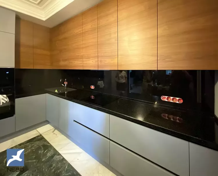 Черный стеклянный однотонный фартук для кухни с древесными фасадами сверху и серыми снизу в Минске от Фарту