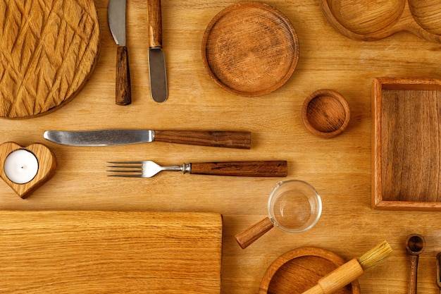 Деревянная бытовая кухонная утварь на столе вид сверху различные предметы для кухни деревянные столовые приборы