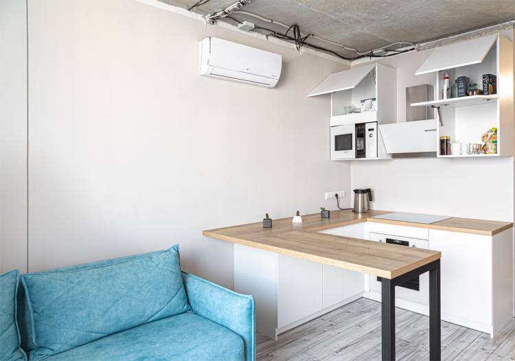 Небольшая п-образная белая кухня с пабоной стойкой для квартиры студии, Екатеринбург