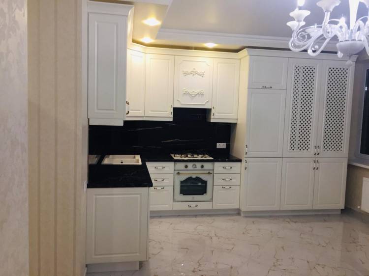 Белая угловая кухня с крашеными фасадами в классическом стиле с пластиковой столешницей