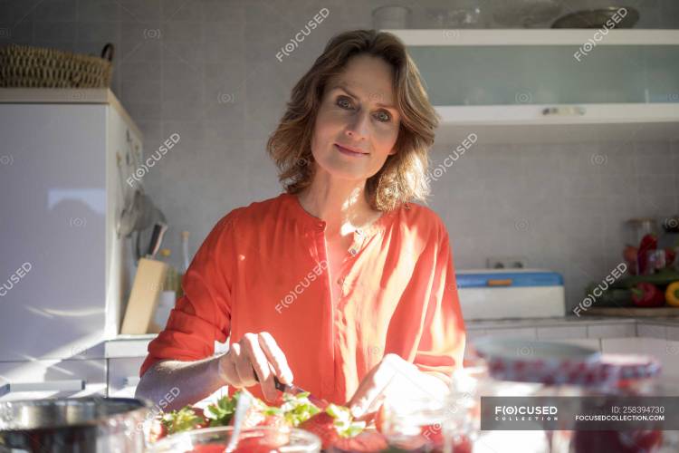 Портрет женщины, готовящей клубничное варенье на кухне дом