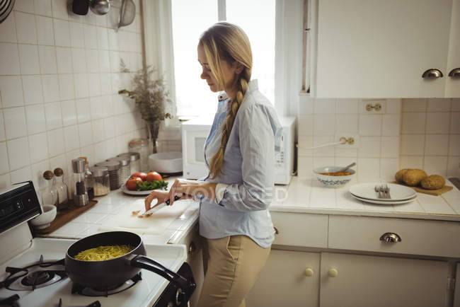 Женщина готовит лапшу на кухне дом