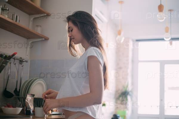 Фотография на тему Красивая девушка на кухне готовит коф