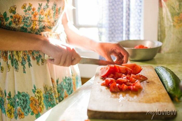 Деревенская девушка режет овощи для салата на кухне, готовить плакаты на стену