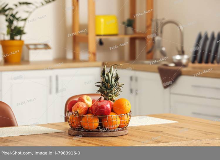 Корзина со свежими фруктами на деревянном столе на кух