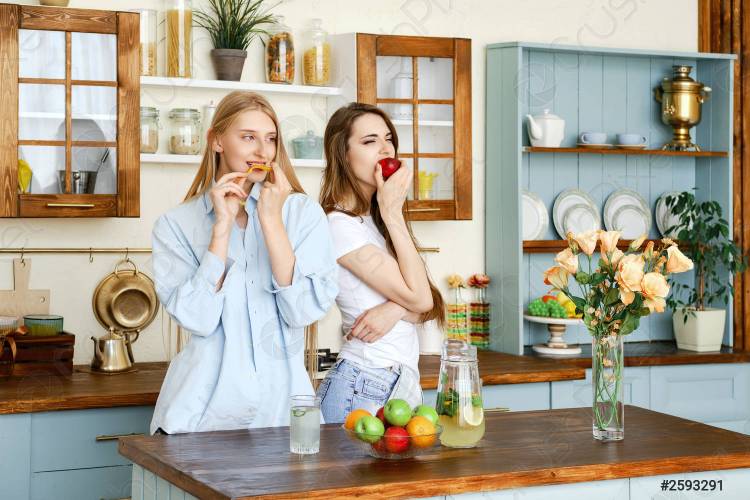 две молодые женщины едят фрукты на кух
