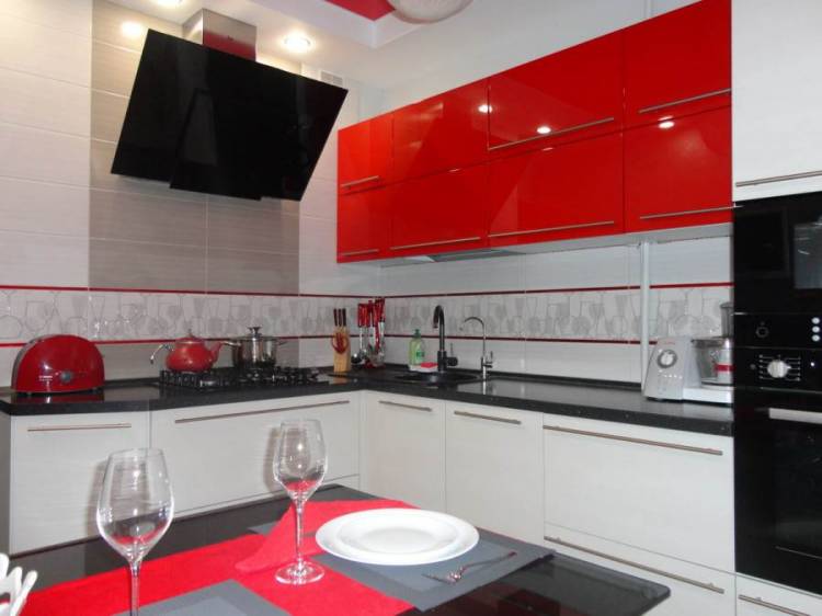 Угловая красно-белая глянцевая кухня с черной столешницей