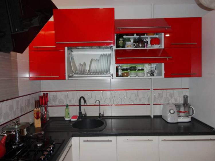 Угловая красно-белая глянцевая кухня с черной столешницей